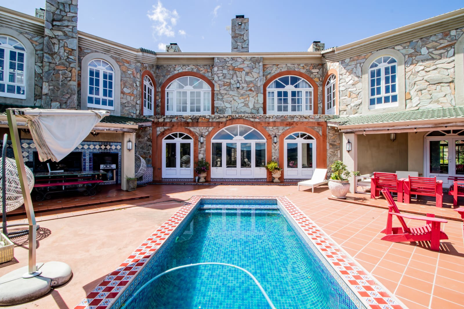 Pool courtyard framed by the stone manor